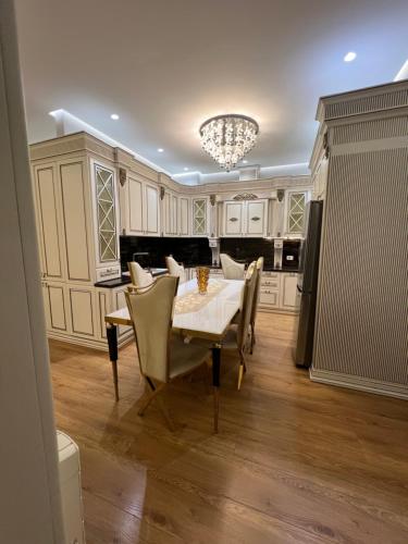 eine Küche mit Tisch und Stühlen und einem Kronleuchter in der Unterkunft tirana delijorgjis appartment in Tirana