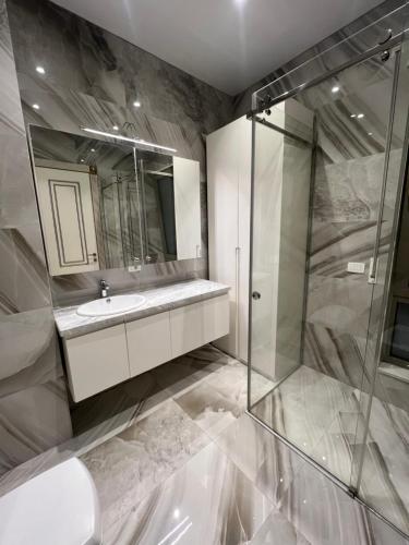 ein Badezimmer mit Waschbecken und Glasdusche in der Unterkunft tirana delijorgjis appartment in Tirana