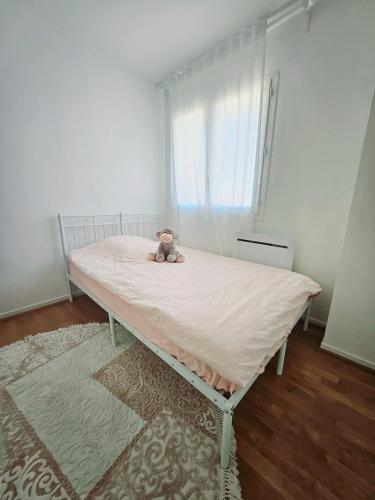 - un ours en peluche assis sur un lit dans une pièce dans l'établissement Maison entiere avec Terrasse proche A1 CDG Asterix, à Saint-Witz