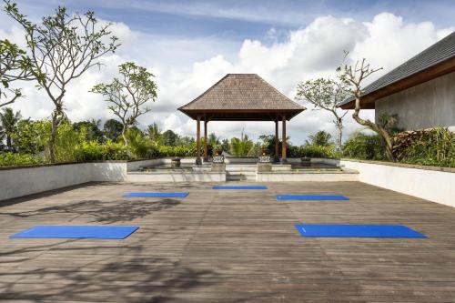 a gazebo with blue mats in a courtyard at Inara Alas Harum in Ubud