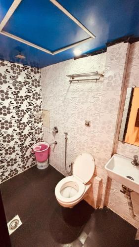 a bathroom with a toilet and a sink at Hotel Garden Palace in Mumbai