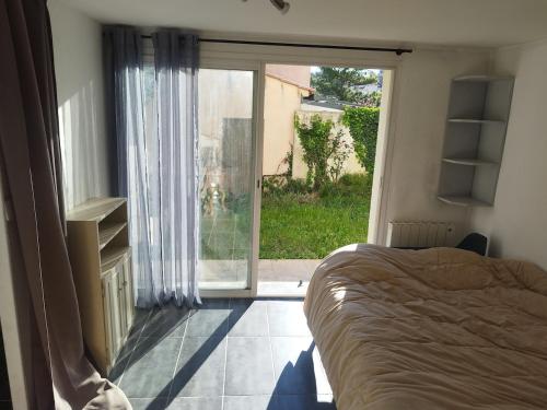 une chambre avec un lit et une grande fenêtre dans l'établissement L'ensoleillé, à Aubagne