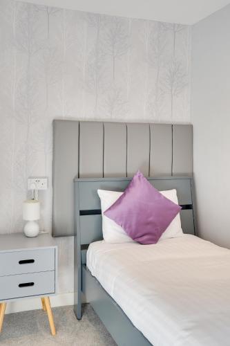a bedroom with a bed with a purple pillow and a nightstand at The County Hotel - Self Check-In, Ultra Fast WI-FI, Free Parking, Central Location in Selkirk