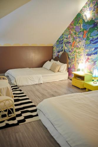 a hotel room with two beds and a colorful wall at Casapapa Home&Space in Talat Amphoe Nakhon Chai Si
