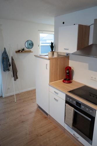 a kitchen with white cabinets and a stove top oven at Ferienwohnung am Tanzberg in Oberkirch