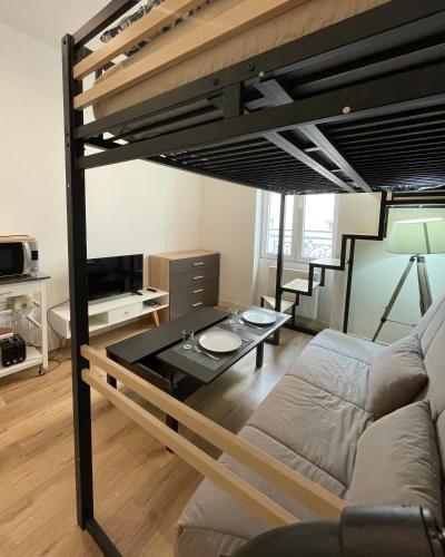 Cette chambre comprend une mezzanine avec un canapé et une table. dans l'établissement T1 Le Aynard, à Villeurbanne