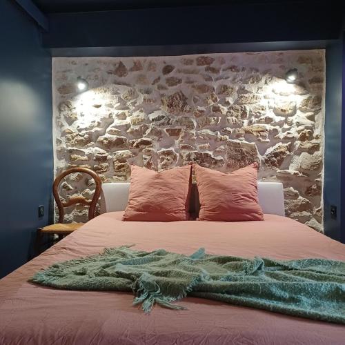une chambre avec un lit avec un mur en pierre dans l'établissement Le trésor des Caraïbes, à Bussy-Saint-Georges