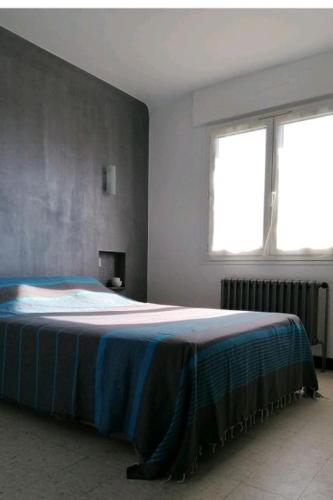 - une chambre avec un lit doté d'une couverture bleue dans l'établissement F2 Climatisé 800m de la Plage, à Canet