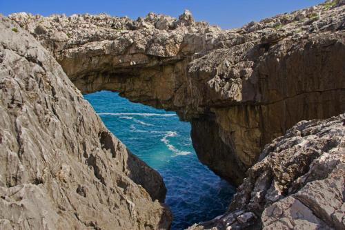 an arch in the rocks near the ocean at Apartamentos la Regoria in Arenas de Cabrales