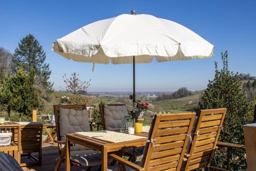 a table and chairs with an umbrella on a patio at Weingut und Ferienhof Josef Huber in Oberkirch