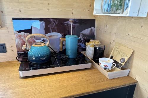 a counter top with a blue pot and cups on it at Weingut und Ferienhof Josef Huber in Oberkirch