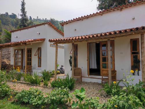 a house with two windows in a yard at INZU Lodge in Gisenyi