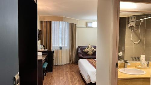 ein Hotelzimmer mit einem Bett und einem Waschbecken in der Unterkunft Fortuna Hotel in Bangkok