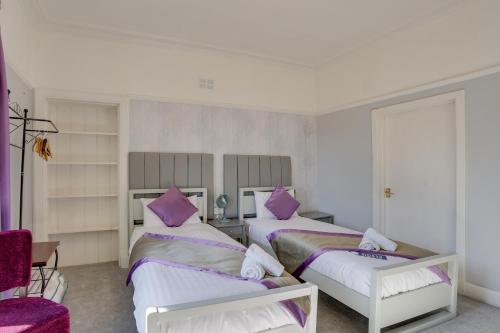 two beds in a room with purple pillows at The County Hotel - Self Check-In, Ultra Fast WI-FI, Free Parking, Central Location in Selkirk