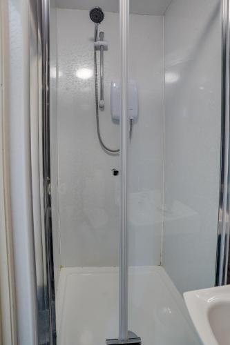 a shower with a glass door next to a sink at The County Hotel - Self Check-In, Ultra Fast WI-FI, Free Parking, Central Location in Selkirk