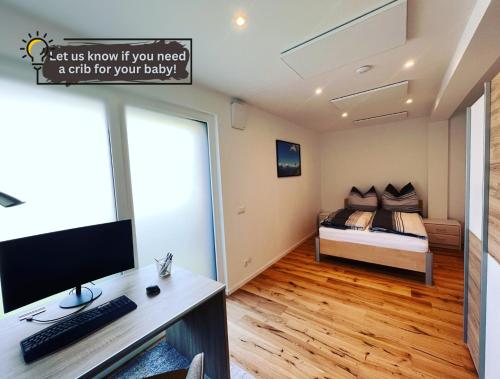 a bedroom with a bed and a desk with a computer at Bergpanorama Lodge — Alpenidylle in Thaur