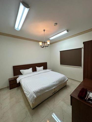 a bedroom with a bed and a flat screen tv at المهاجرين فرع الحزام in Medina