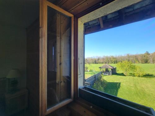 a window in a room with a view of a field at La Grange de Capucine, gite de caractère in Chainaz-les-Frasses