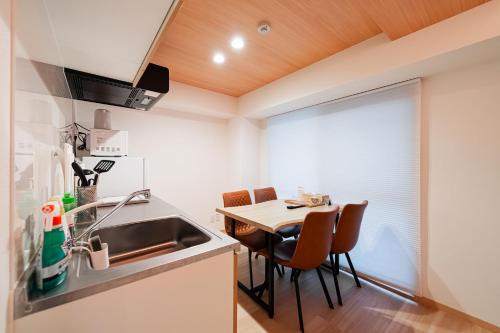 a kitchen with a table and chairs in a room at Cu 道頓堀 1号店 in Osaka