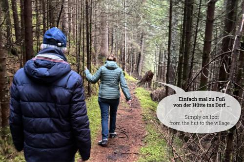 two people walking on a trail in the woods at Nockstern Hütte in Ebene Reichenau