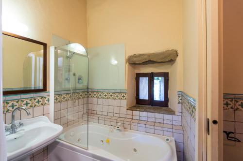 a bathroom with a tub and a sink at Santa Flora by PosarelliVillas in Capolona