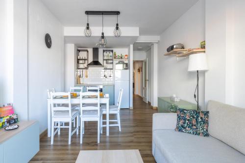 a living room and kitchen with a table and chairs at Rodas Apartment in Torrevieja