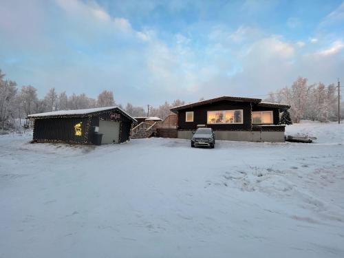 a car parked in front of a house in the snow at Cabin in Jarfjord, Sør-Varanger in Karpbukt