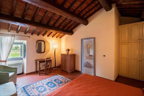 a bedroom with a bed and a table in a room at Santa Flora by PosarelliVillas in Capolona