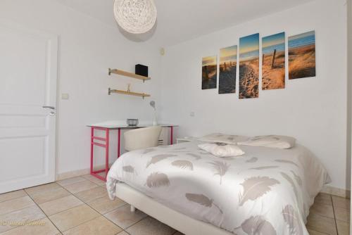 - une chambre avec un lit, un bureau et des photos dans l'établissement Superbe propriété, piscine, salle de jeux, appareils de sport, à Saint-Aunès