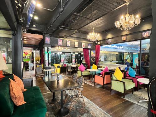 ein Restaurant mit farbenfrohen Möbeln und Tischen und Stühlen in der Unterkunft Fortuna Hotel in Bangkok