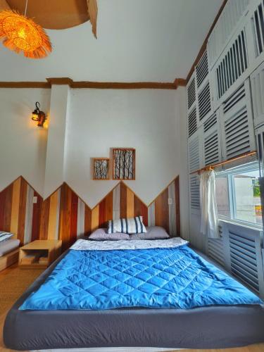 a bedroom with a large bed with blue sheets at Sea Urchin Homestay in Phan Rang