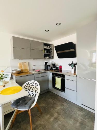 a kitchen with white cabinets and a table and chairs at Fewo Saur in Immenstaad am Bodensee
