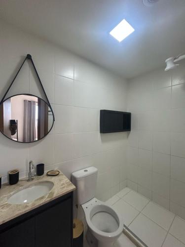 a bathroom with a toilet and a sink and a mirror at Vida Mar 14 andar com vista incrível do por do sol in Goiânia