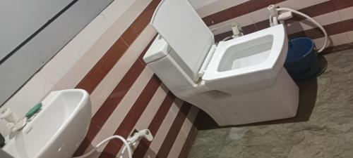 a bathroom with a toilet and a urinal on a wall at Radharani seva in Jāmb