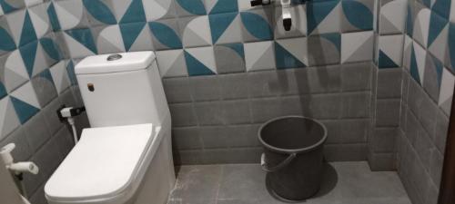 a bathroom with a toilet and a trash can at Radharani seva in Jāmb