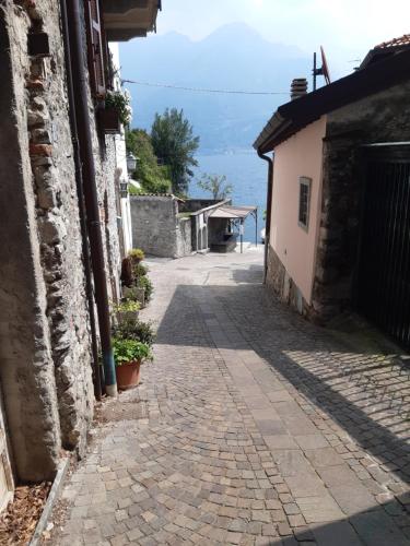 an alleyway between two buildings with the ocean in the background at a 2 passi dal lago in Oliveto Lario