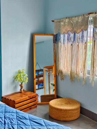 a dressing room with a mirror and a bed and a stool at Sea Urchin Homestay in Phan Rang