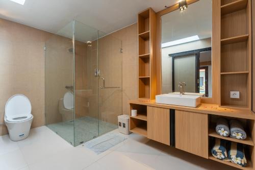a bathroom with a toilet and a sink and a shower at Bintang Bungalow in Nusa Penida