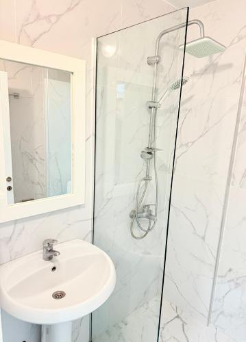 a bathroom with a sink and a shower at Helia Seaside Hotel in Sarandë