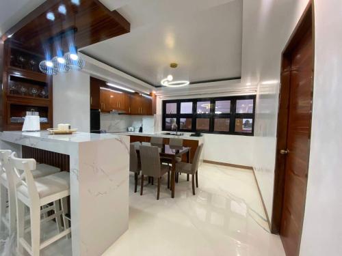 a kitchen with a bar with chairs and a table at Aloha - Your Stylish City Escape in Gate
