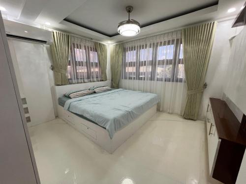 a bedroom with a bed and two windows at Aloha - Your Stylish City Escape in Gate