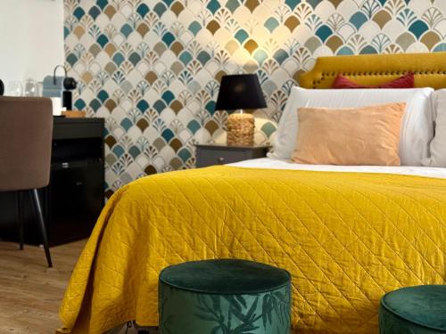 a bedroom with a yellow bed with two green stools at Palazzina300 in Treviso