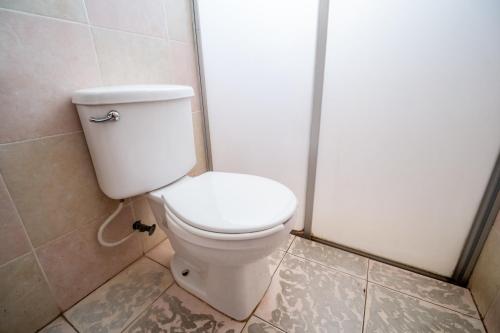 a bathroom with a toilet in a shower stall at OYO Hotel Betsua Vista Hermosa, Huatulco in Santa Cruz Huatulco