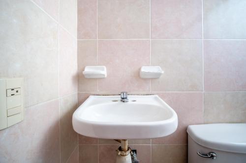 a bathroom with a white sink and a toilet at OYO Hotel Betsua Vista Hermosa, Huatulco in Santa Cruz Huatulco
