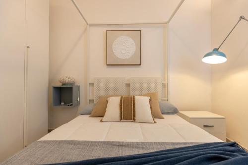 Un dormitorio con una gran cama blanca con almohadas. en Villa Elysian con piscina privata, en Marzamemi