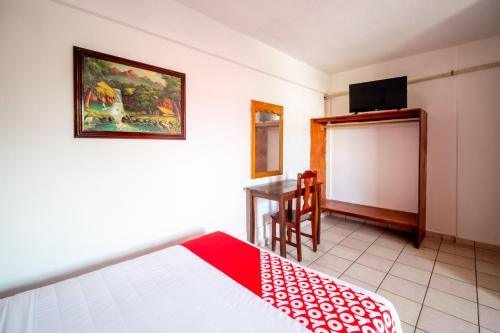 a bedroom with a bed and a table with a television at OYO Hotel Betsua Vista Hermosa, Huatulco in Santa Cruz Huatulco