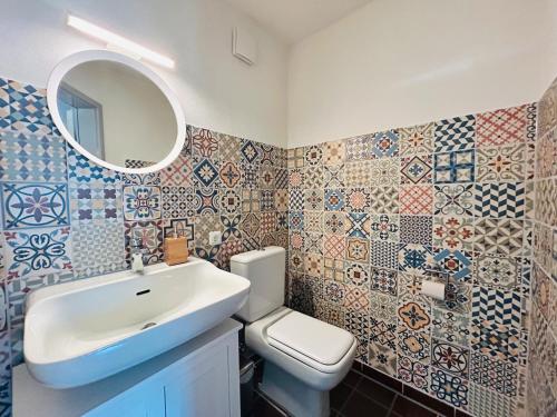 a bathroom with a sink and a toilet and tiles at Ferienwohnung Kuckucksnest in Bad Wildbad