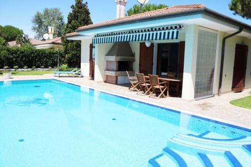a swimming pool in front of a house at Francesca in Isola Albarella