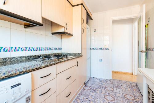 una cocina con estufa y fregadero en Mediterráneo, en Benicàssim