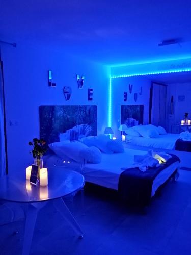 Cette chambre bleue comprend 2 lits et une table. dans l'établissement L'étincelle, à Saint-Christol-lès-Alès